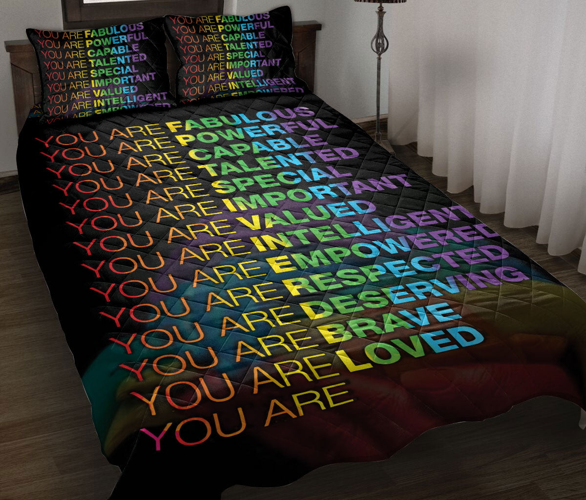 Rainbow affirmation quilt blanket styled on a bed with matching colorful affirmation pillow covers