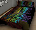 Black quilt blanket with vibrant rainbow affirmation typography styled in a modern bedroom