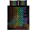 Full view of a black rainbow affirmation quilt blanket with coordinating colorful pillow covers
