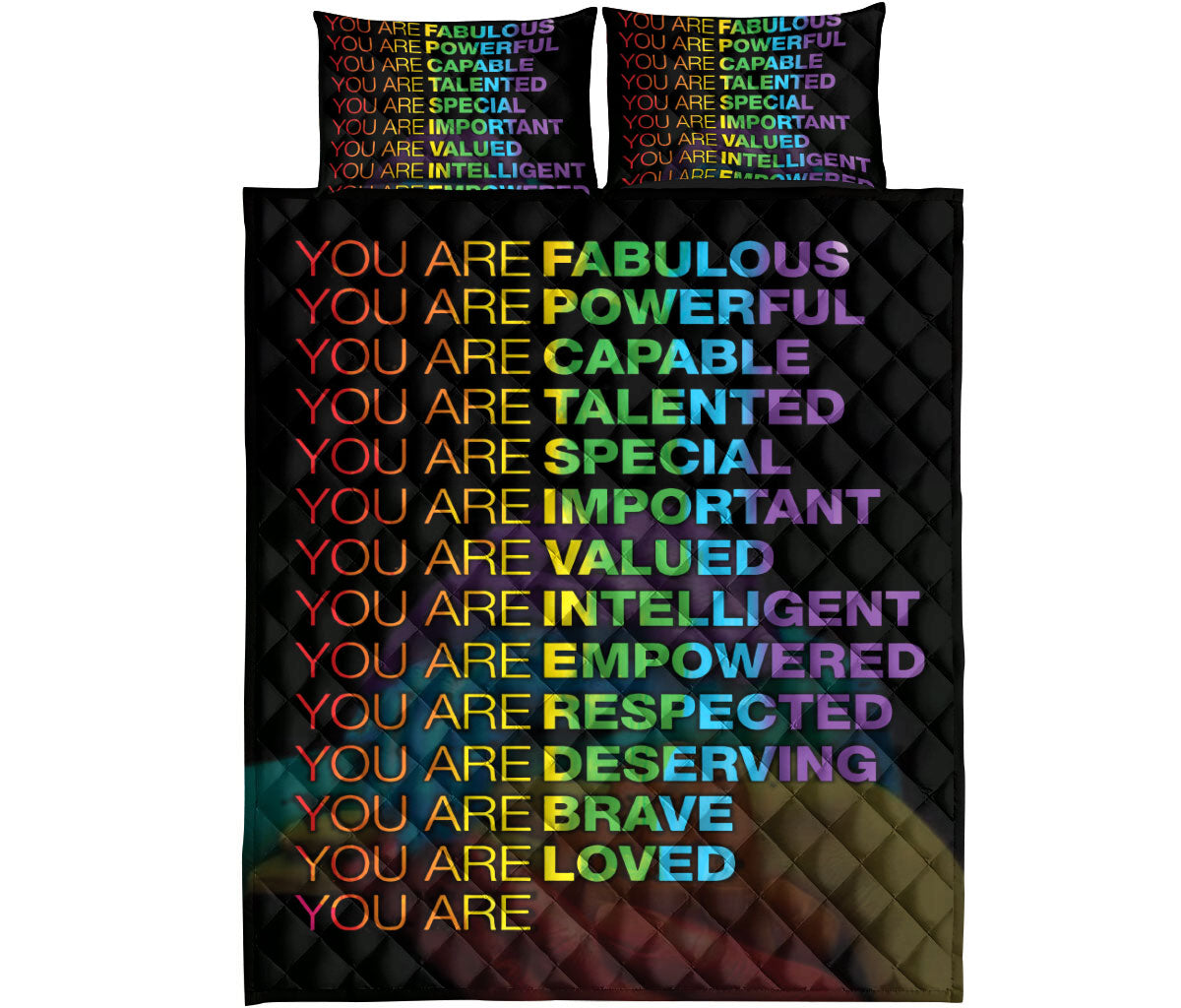 Full view of a black rainbow affirmation quilt blanket with coordinating colorful pillow covers