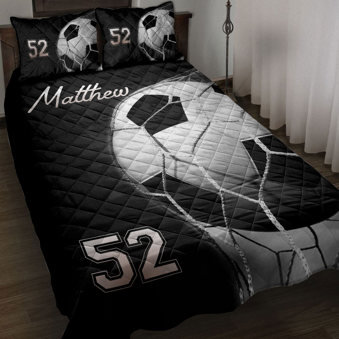 Black and white soccer ball quilt blanket styled on a bedroom with coordinated bedding