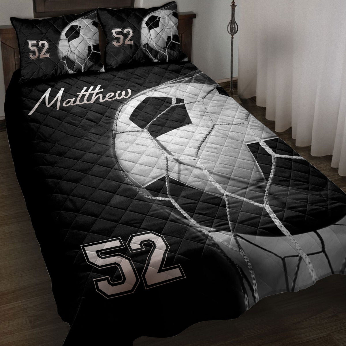 Black and white soccer ball quilt blanket styled on a bedroom with coordinated bedding