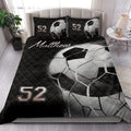 Black soccer ball quilt blanket styled across a modern bedroom with matching pillow designs