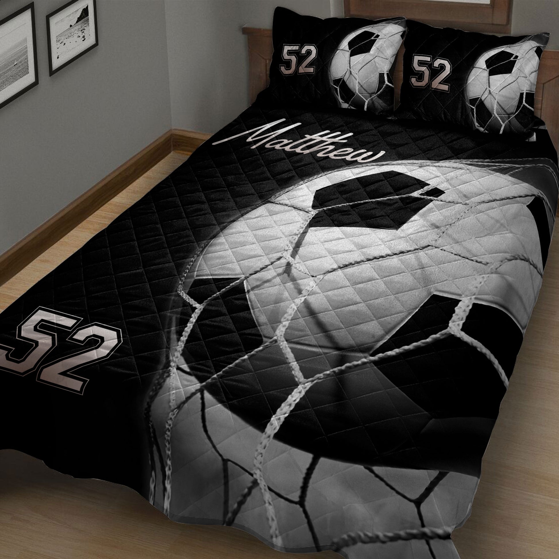Close bedroom view of a black and white soccer ball quilt blanket with goal-net artwork