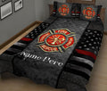 Fire rescue quilt blanket on a bed featuring a large firefighter emblem, stars, and black, gray, and red design