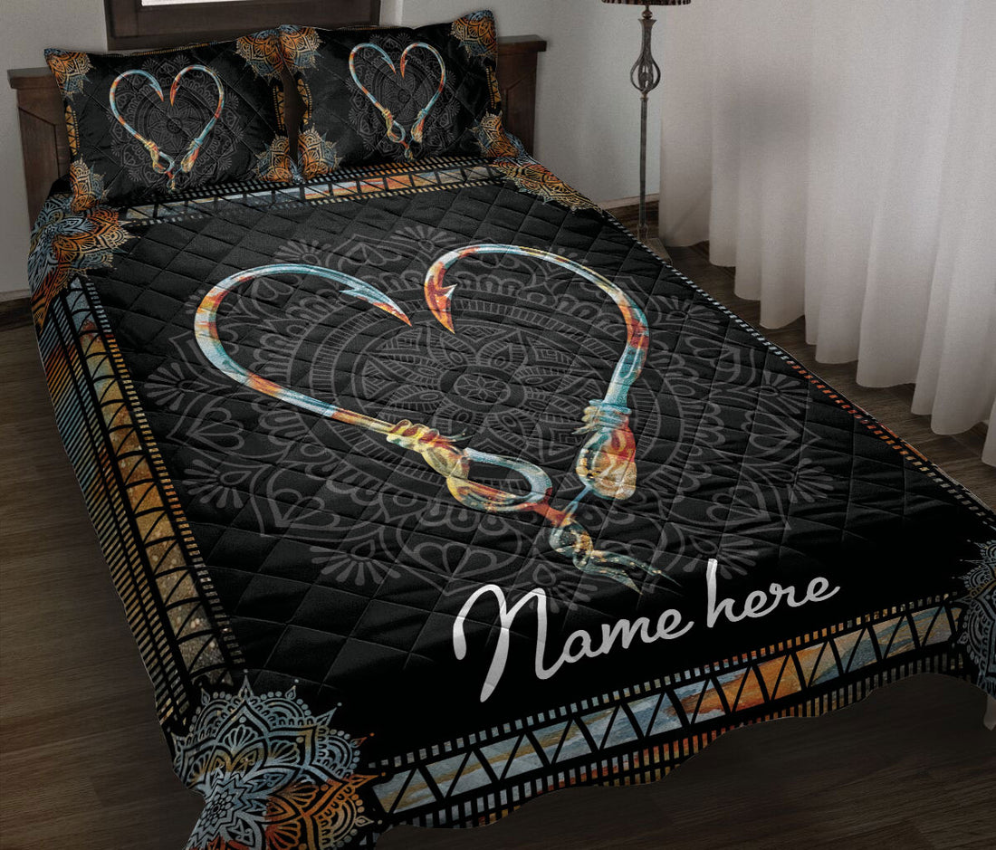 Black fishing quilt blanket displayed on a bed with heart-shaped hooks and ornate copper and teal borders