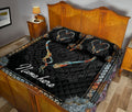 Fishing hook heart quilt blanket styled across a wooden bedroom with matching patterned pillows