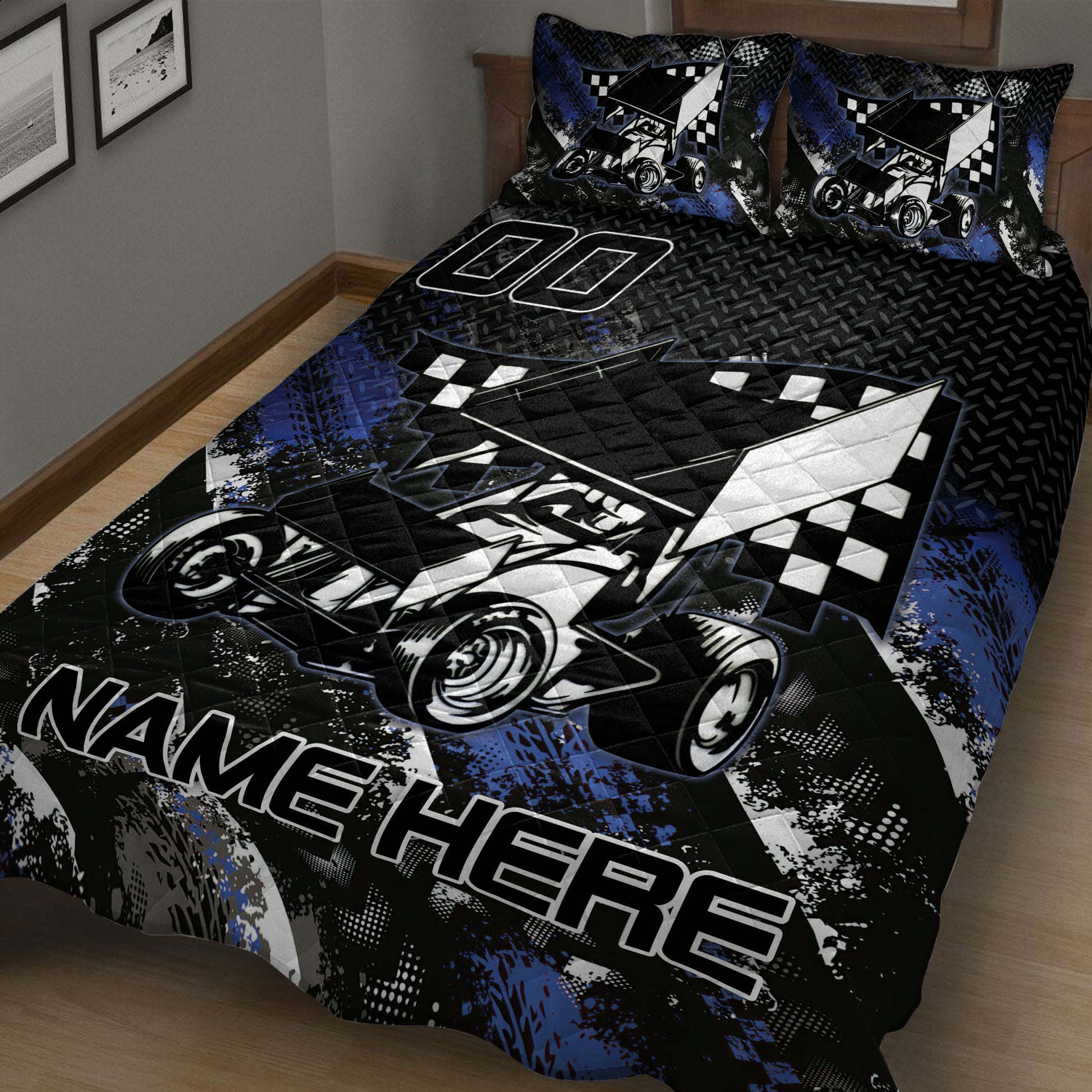 Close view of a dirt track racing quilt blanket featuring a sprint car, checkered flags, and blue accents